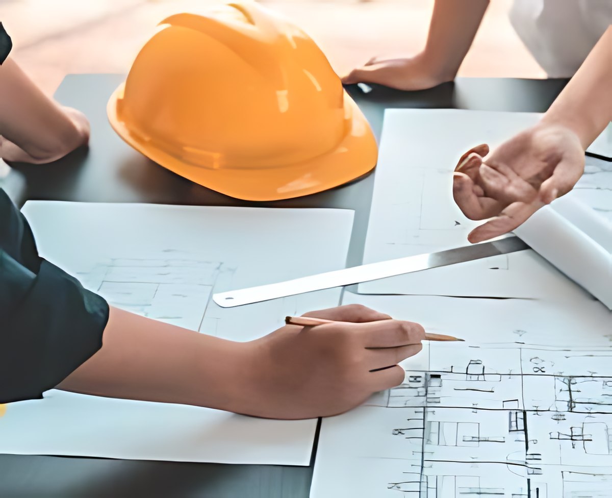 Ingénieurs et architecte examinant des plans de structure sur une table
