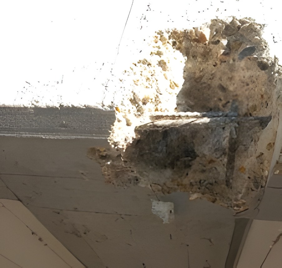 Éclatement du béton d'une poutre laissant apparaître des armatures corrodées